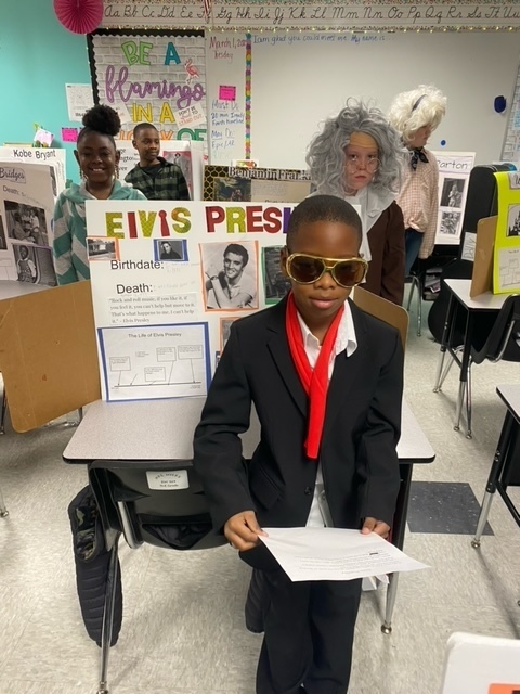 East Amory child dressed as Elvis Pressley with a backdrop behind him